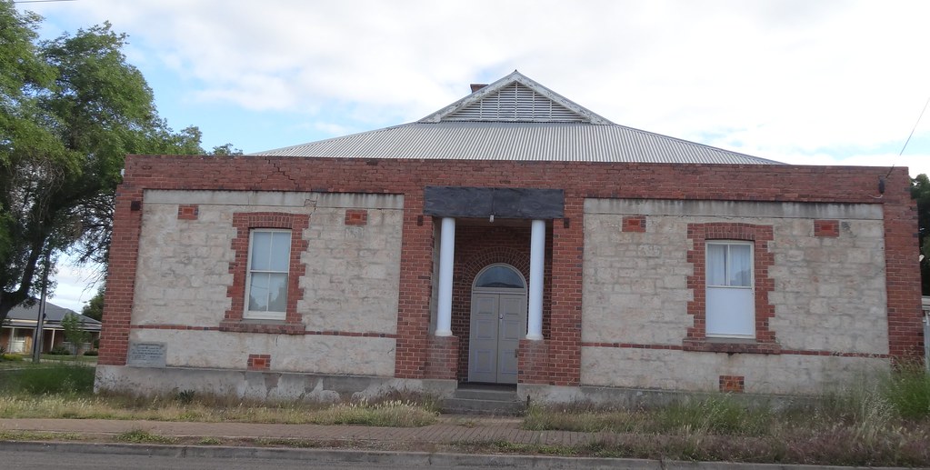 Older stone building with brick trim and a metal roof